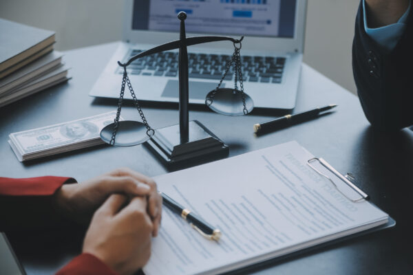 Justice and law concept.Male judge in a courtroom with the gavel, working with, computer and docking keyboard, eyeglasses, on table in morning light